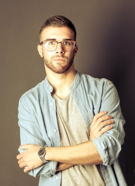 Mutlu bir casual adam ayakta karanlık bir arka plan üzerinde izole portresi