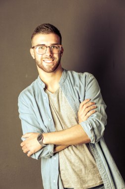 Mutlu bir casual adam ayakta karanlık bir arka plan üzerinde izole portresi