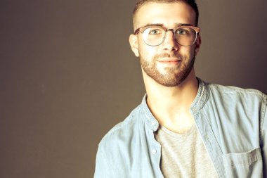 Mutlu bir casual adam ayakta karanlık bir arka plan üzerinde izole portresi