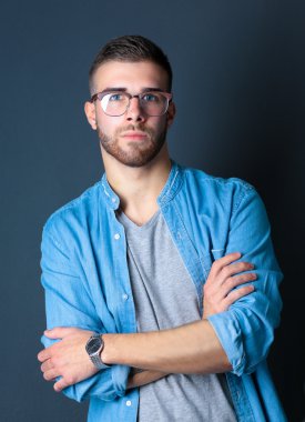 Mutlu bir casual adam ayakta karanlık bir arka plan üzerinde izole portresi