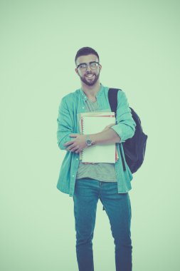 Beyaz arka plan üzerinde izole kitap tutan bir okul çantası olan bir erkek öğrenci