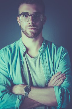 Mutlu bir casual adam ayakta karanlık bir arka plan üzerinde izole portresi