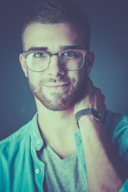 Mutlu bir casual adam ayakta karanlık bir arka plan üzerinde izole portresi