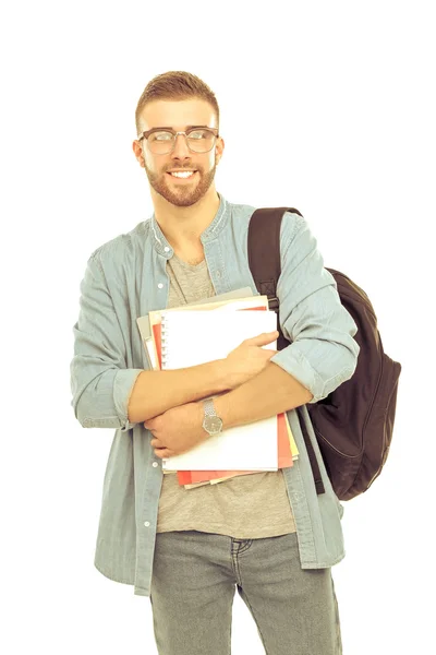 Un estudiante masculino con una bolsa de la escuela sosteniendo libros aislados sobre fondo blanco — Foto de Stock