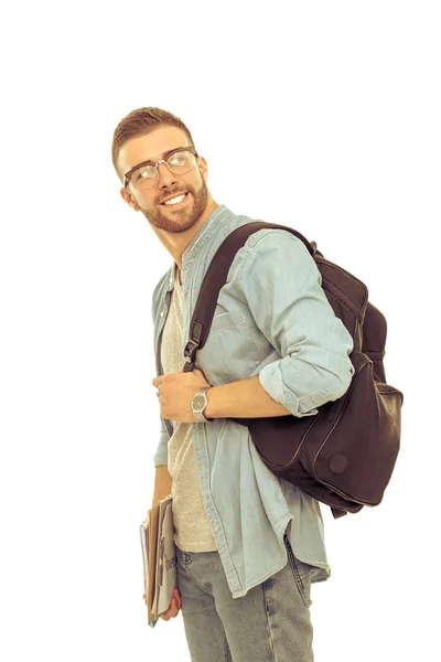 Un estudiante masculino con una bolsa de la escuela sosteniendo libros aislados sobre fondo blanco — Foto de Stock