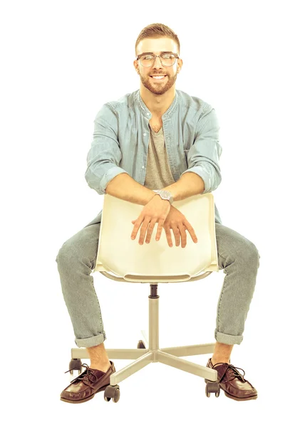 Young man sitting on the chair isolated over white background — Stock Photo, Image