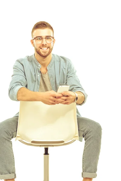 Jeune homme assis sur la chaise isolé sur fond blanc — Photo