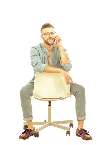 Young man sitting on chair and using mobile phone — Stock Photo, Image