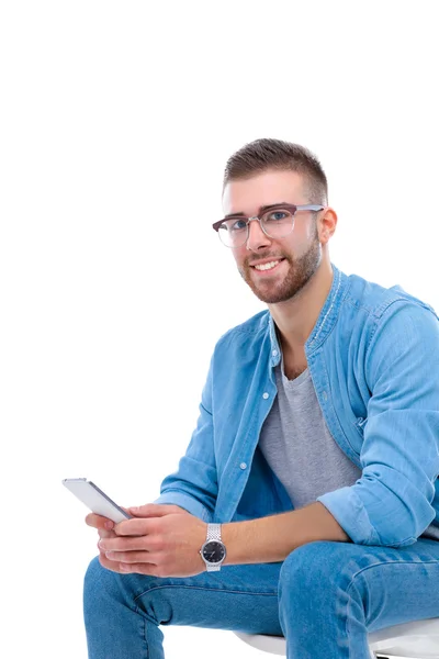 Young man sitting on chair and using mobile phone — Stock Photo, Image