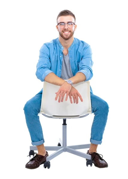 Mladý muž sedí na židli, izolované na bílém pozadí — Stock fotografie