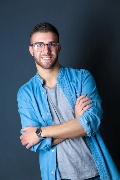 Retrato de un hombre casual feliz de pie aislado sobre un fondo oscuro —  Fotos de Stock