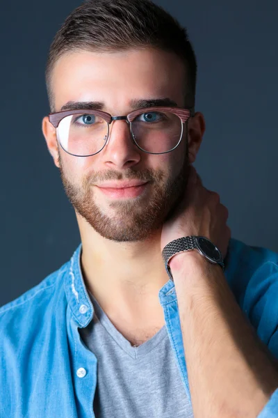 Portret van een gelukkig casual man permanent geïsoleerd op een donkere achtergrond — Stockfoto