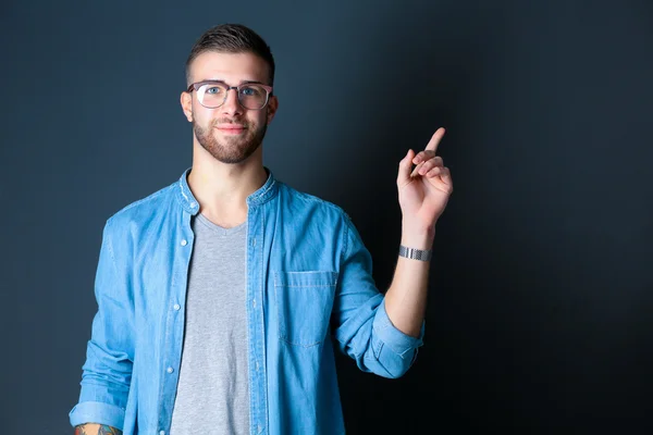 Portrait of a smiling young man pointing up — Stock Photo, Image