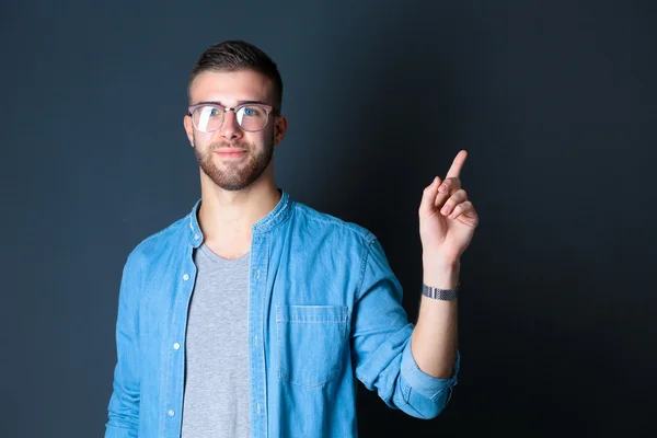 Portrait of a smiling young man pointing up — Stock Photo, Image