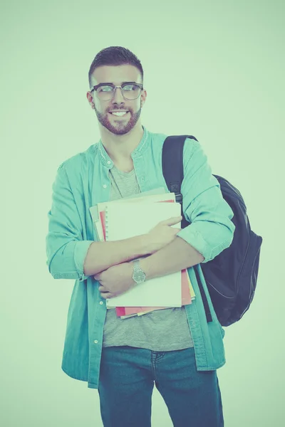 Un estudiante masculino con una bolsa de la escuela sosteniendo libros aislados sobre fondo blanco — Foto de Stock