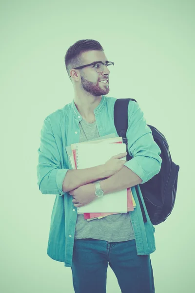 Un estudiante masculino con una bolsa de la escuela sosteniendo libros aislados sobre fondo blanco — Foto de Stock