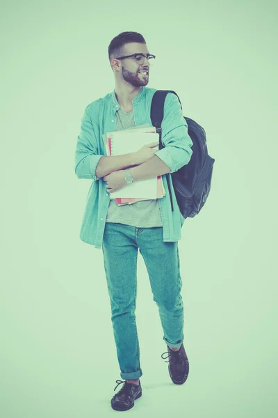 Un estudiante masculino con una bolsa de la escuela sosteniendo libros aislados sobre fondo blanco — Foto de Stock