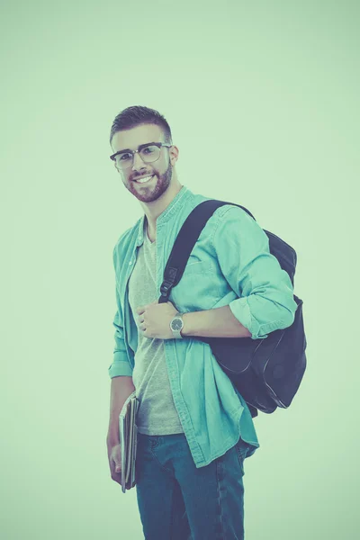 Een mannelijke student met een schooltas houden boeken geïsoleerd op witte achtergrond — Stockfoto