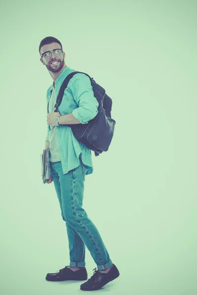Un estudiante masculino con una bolsa de la escuela sosteniendo libros aislados sobre fondo blanco —  Fotos de Stock