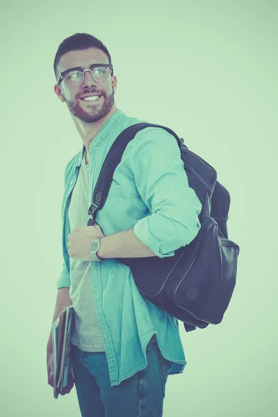 Un estudiante masculino con una bolsa de la escuela sosteniendo libros aislados sobre fondo blanco — Foto de Stock