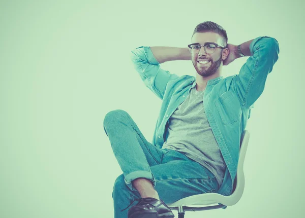 Young man sitting on the chair isolated over white background — Stock Photo, Image