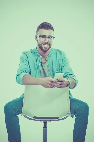 Jongeman zit op de stoel geïsoleerd op witte achtergrond — Stockfoto