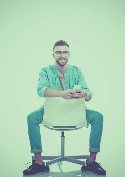 Young man sitting on the chair isolated over white background — Stock Photo, Image