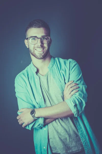 Retrato de un hombre casual feliz de pie aislado sobre un fondo oscuro — Foto de Stock