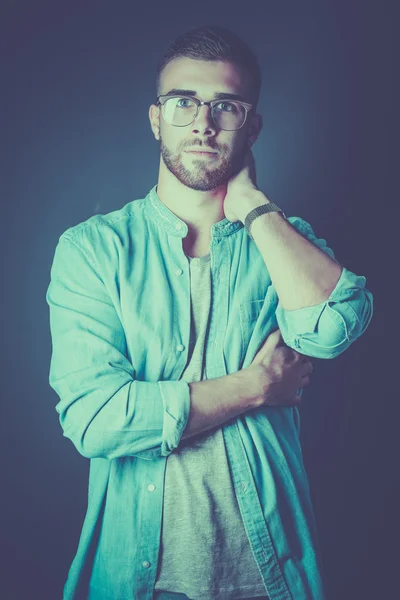 Retrato de um homem casual feliz de pé isolado em um fundo escuro — Fotografia de Stock