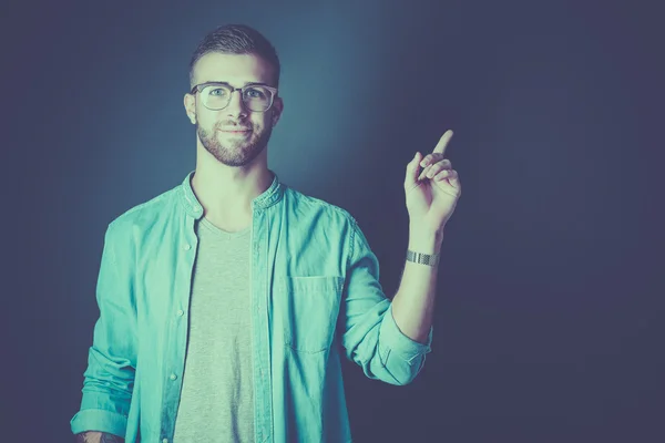 Portrait of a smiling young man pointing up — Stock Photo, Image