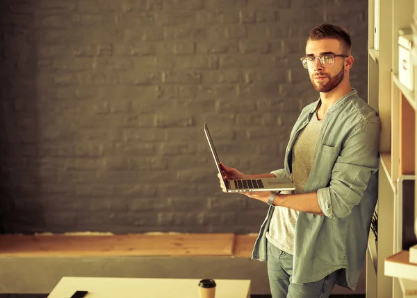 Ung man som håller laptop — Stockfoto