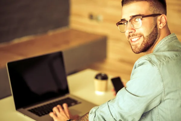 Young man works on the laptop — Stock Photo, Image