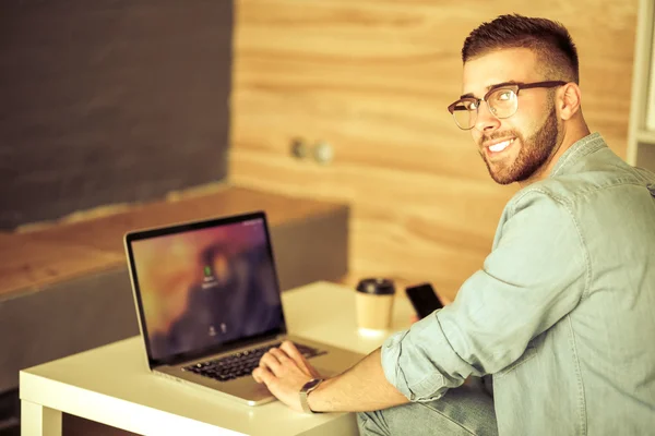 Young man works on the laptop — Stock Photo, Image