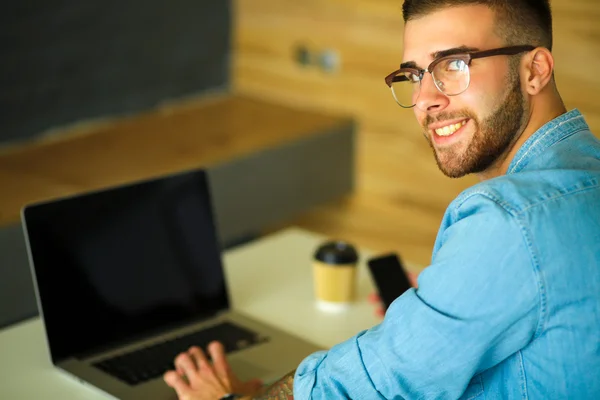 Jonge man werken op de laptop — Stockfoto