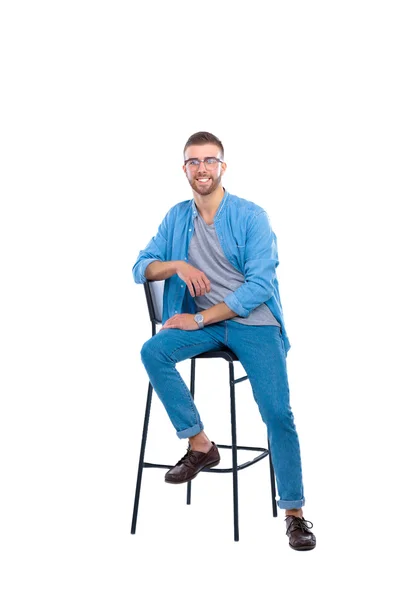 Jeune homme assis sur la chaise isolé sur fond blanc — Photo