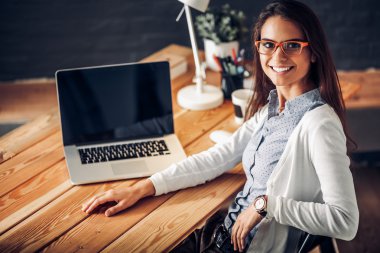 Masada oturan genç bir kadın.