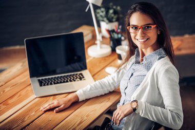 Masada oturan genç bir kadın.