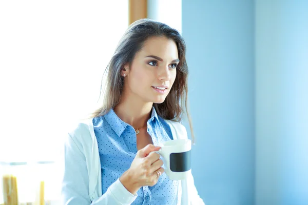 Szczęśliwa kobieta picia herbaty w kuchni w domu — Zdjęcie stockowe