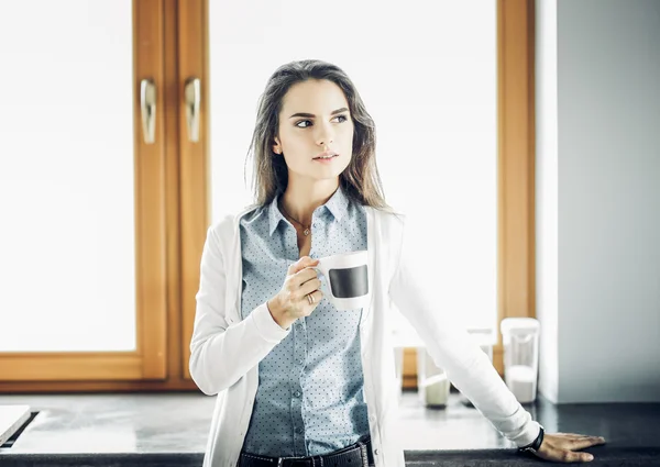 Mujer feliz bebiendo té en la cocina en casa —  Fotos de Stock