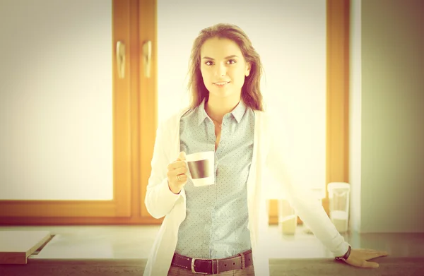 Glückliche Frau trinkt Tee in der Küche zu Hause — Stockfoto