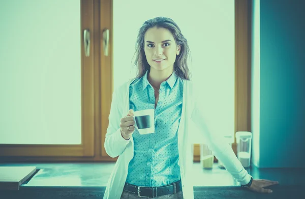 Glückliche Frau trinkt Tee in der Küche zu Hause — Stockfoto