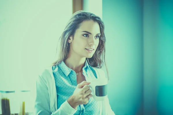 Happy woman drinking tea in the kitchen at home — Stock Photo, Image