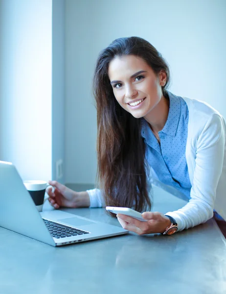 Unga kvinnliga stående nära skrivbord — Stockfoto