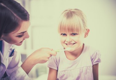 Diş hekiminde dişçi ve küçük kız.