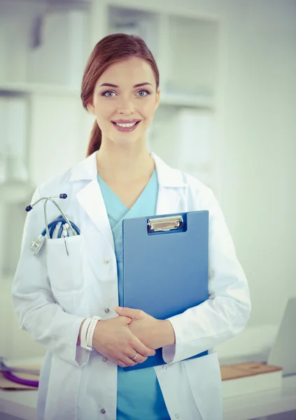 Femme médecin souriante avec un dossier en uniforme debout à hosp — Photo