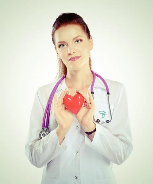 Jonge vrouw arts met een rood hart, geïsoleerd op witte achtergrond — Stockfoto