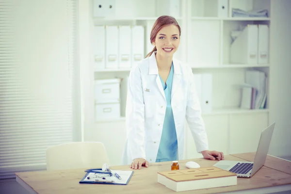 Jonge dokter vrouw stond in de buurt van tabel in het ziekenhuis — Stockfoto