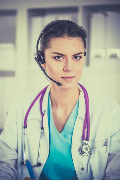 Doctor wearing headset sitting behind a desk with laptop — Stock Photo, Image