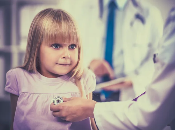 Médico femenino examinando a un niño con estetoscopio en cirugía — Foto de Stock