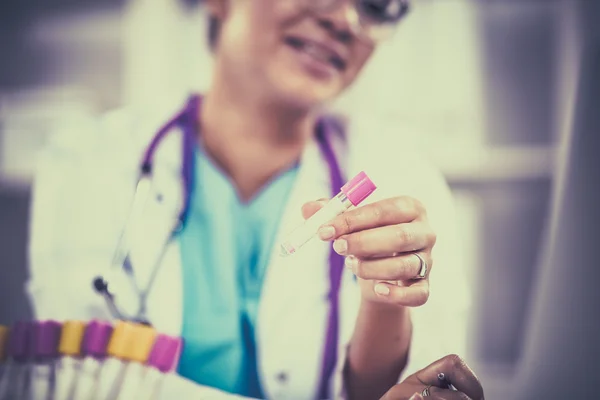 Mulher pesquisadora é cercada por frascos e frascos médicos, isolados em fundo branco — Fotografia de Stock